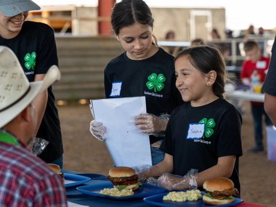 young 4-H member presenting food to judge