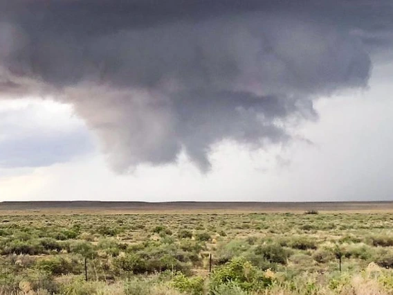 Desert landscape with a dark cloud in the sky above