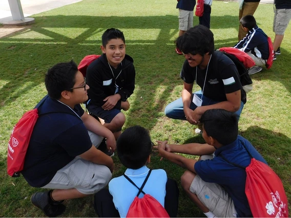 4-H members talking in grass