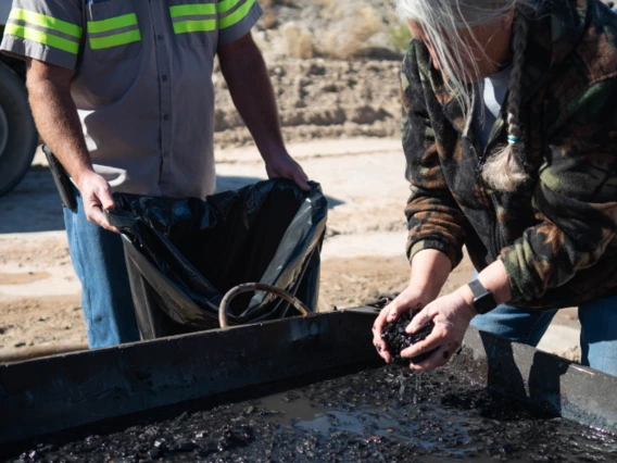 person collecting biochar from kiln