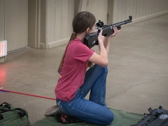 Daisy Johnson shooting rifle in the kneeling position