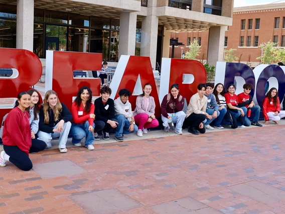 Photo of a group of teens in from of a University of Arizona sign