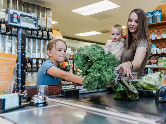 mother and two children at the grocery store counter