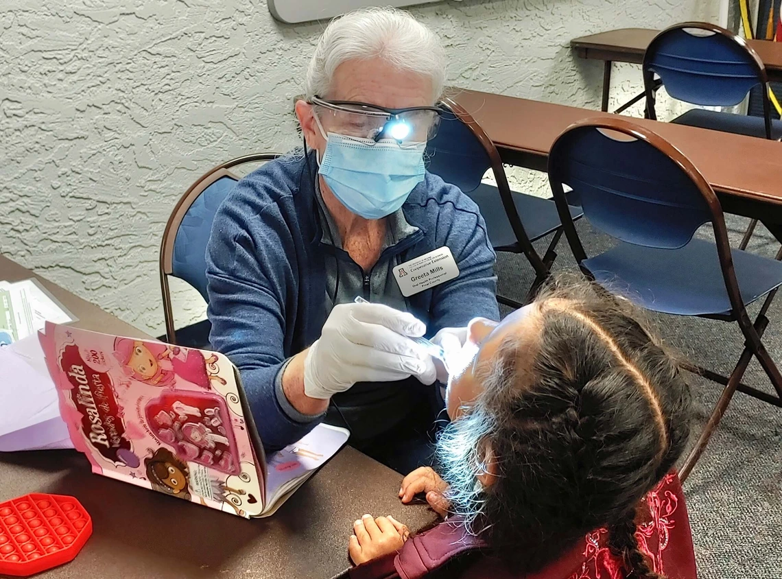 Photo of a woman doiing a dental exam