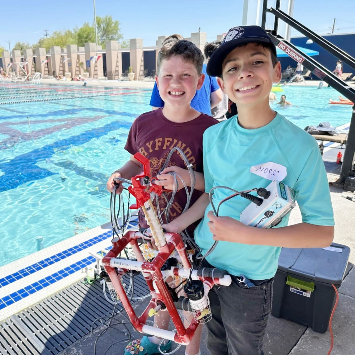 4-h youth with underwater robot near pool