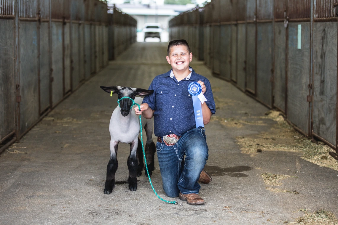 4-H youth with lamb and ribbon