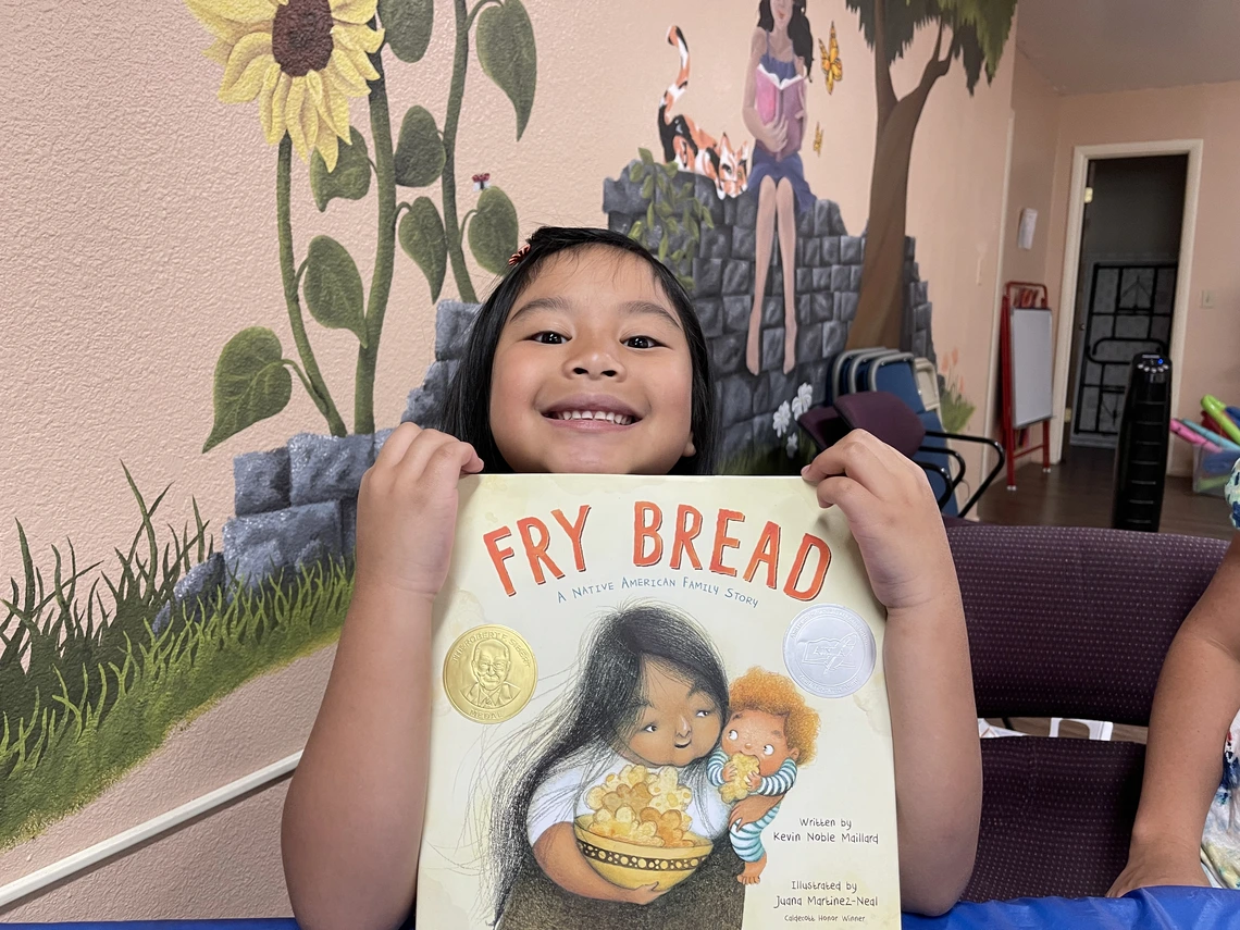 Child holding the book Fry Bread