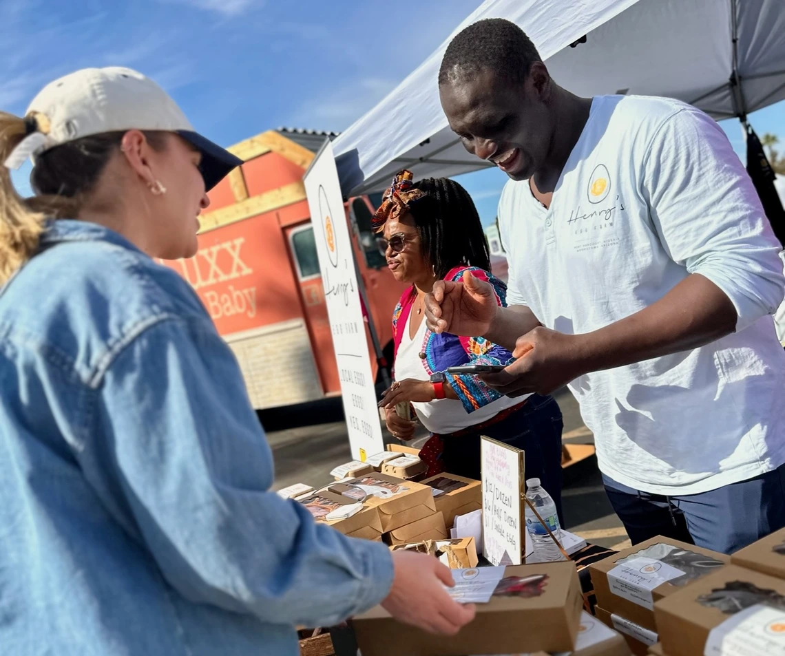 Photo of Henry Osineke Eziama selling eggs at a farmers market
