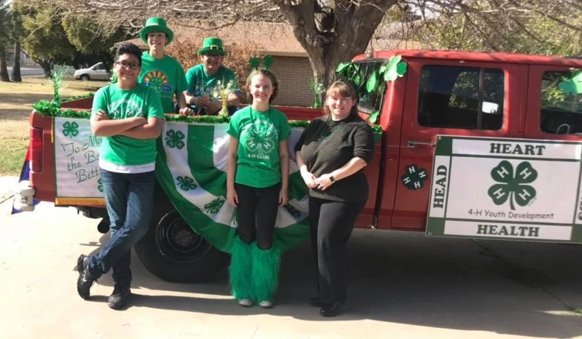4-H youth in front of old truck with 4-H decorations