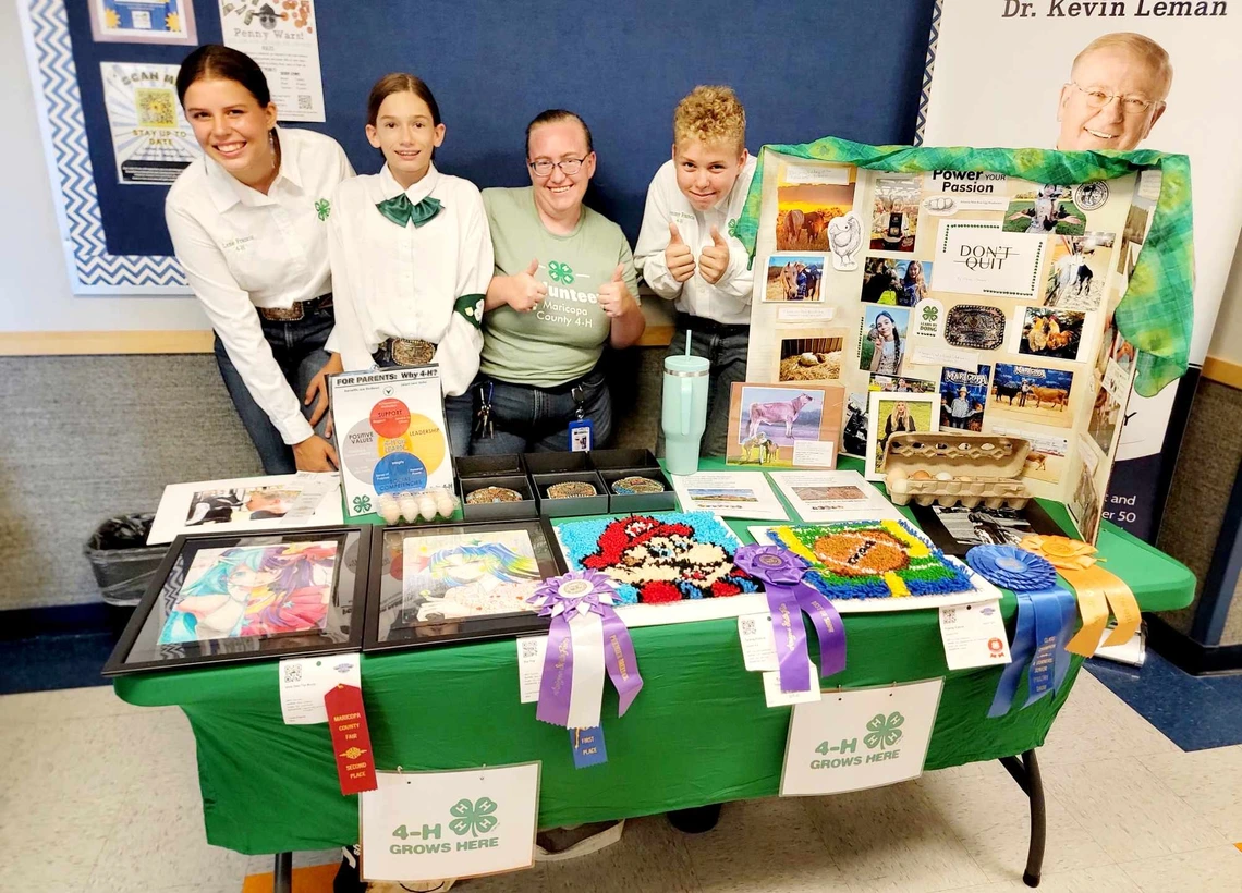 4-H youh with poster and ribbons presenting at tabling event