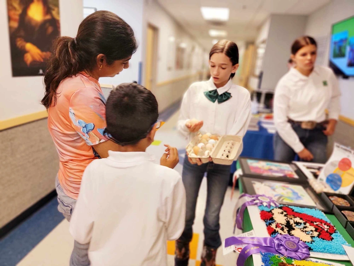 4-H youth showing eggs at event table