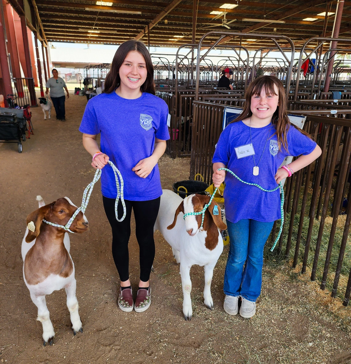 4-H youth with two goats at fair stock yards