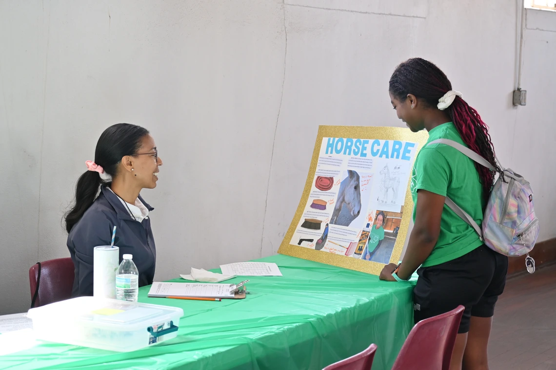 Girl showing her fair project to a judge