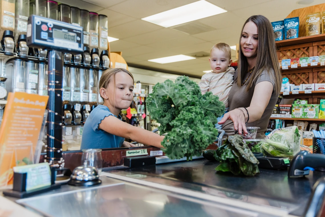 mother and two children at the grocery store counter