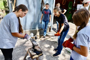 Photo of girls blacksmithing