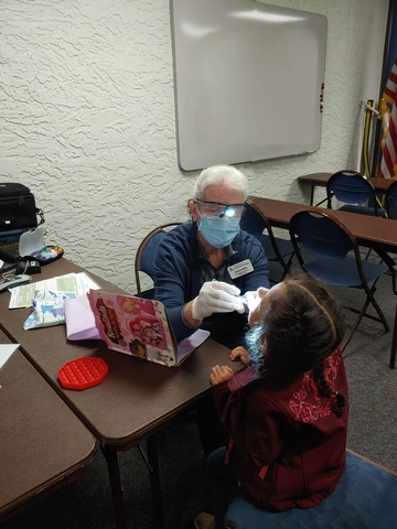 Photo of Greeta Mills giving a dental exam