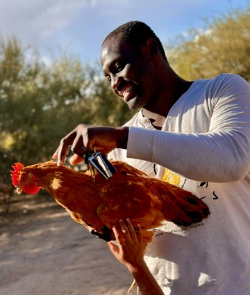 Photo of a man holding a chicken