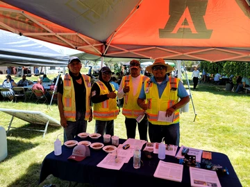 volunteers standing behind soil sampling table