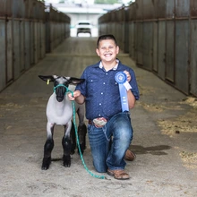 4-H youth with lamb and ribbon