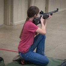 Daisy Johnson shooting rifle in the kneeling position