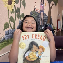 Child holding the book Fry Bread